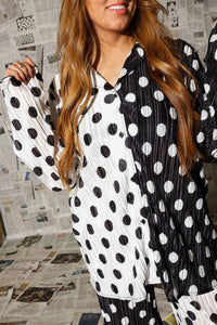 Person wearing a black and white polka dot outfit with a newspaper background