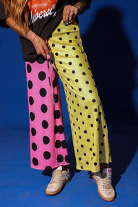 Person wearing colorful polka dot pants on a blue background