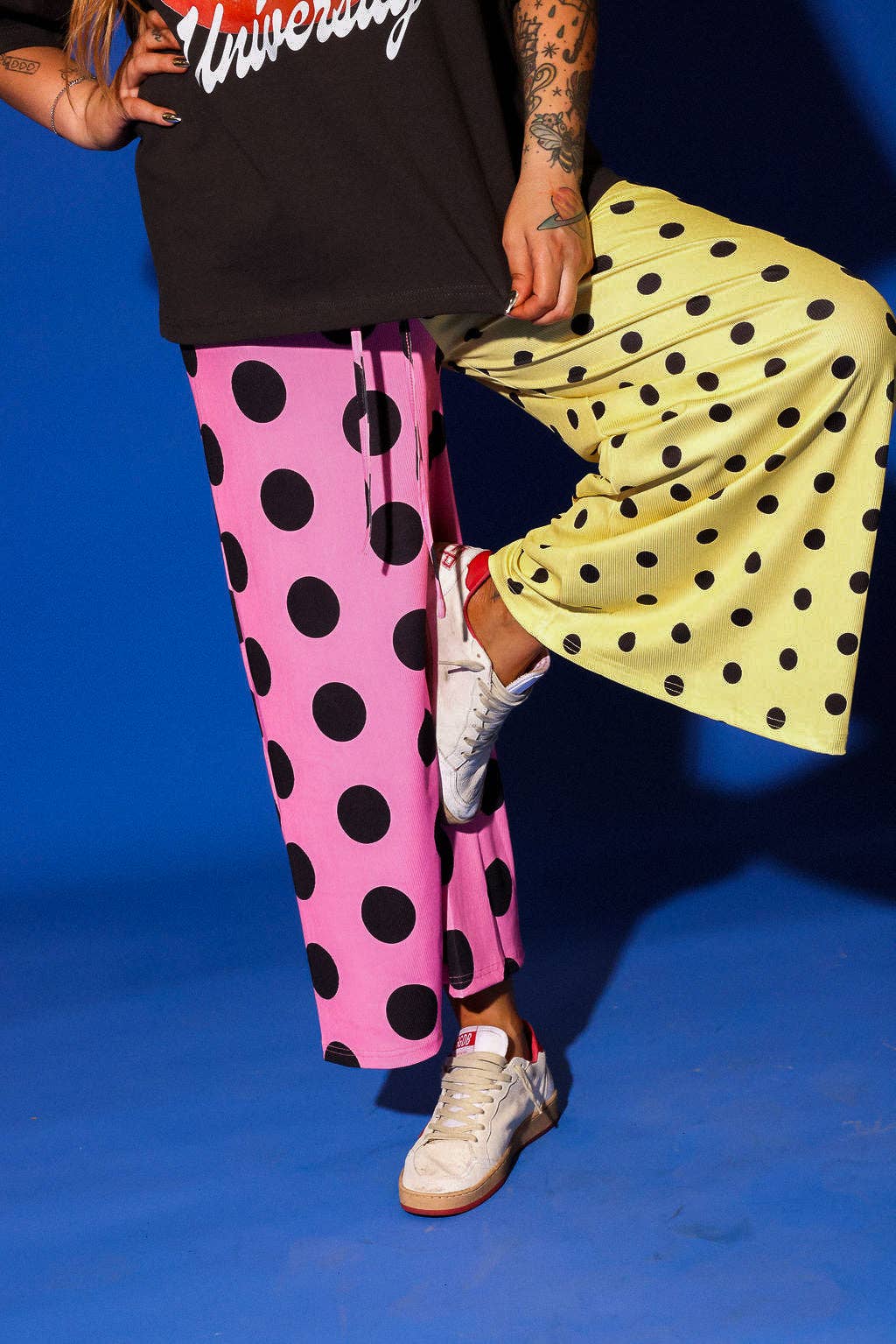 Person wearing polka dot pants and a yellow skirt with a blue background