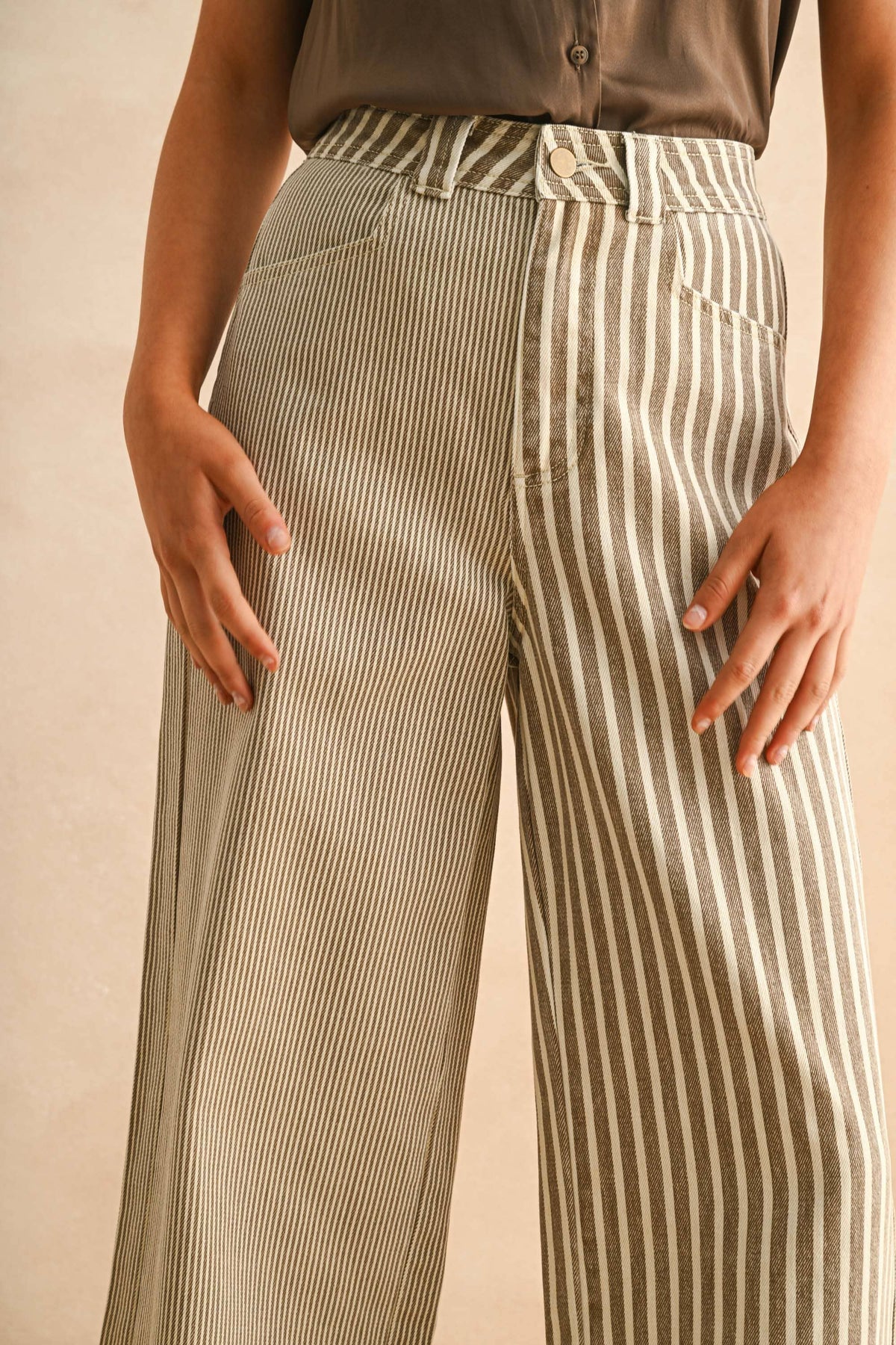 Striped pants worn by a person on a beige background