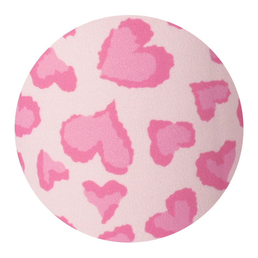Round pink fabric close up with heart pattern on a white background