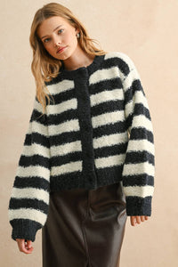 Woman wearing a navy and white striped sweater against a beige background